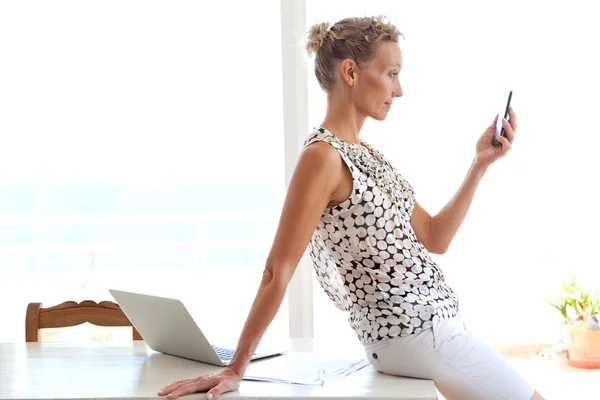 Woman using a smartphone in office — Stok fotoğraf