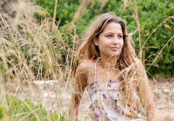 Giovane donna tra le dune vegetate di una spiaggia — Foto Stock