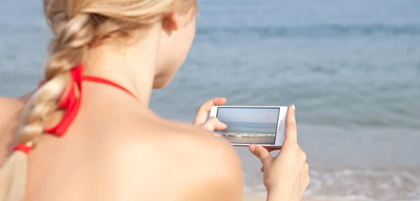 Mulher usando smartphone na praia — Fotografia de Stock