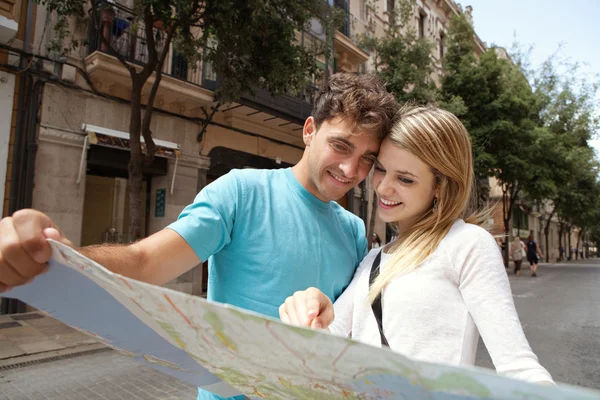 Tourist couple reading a map — 图库照片