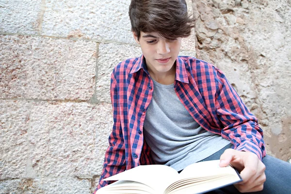 Student boy reading an open book — Zdjęcie stockowe