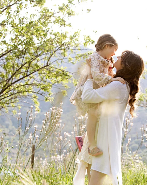 Mother and daughter hugging in a spring field — 스톡 사진