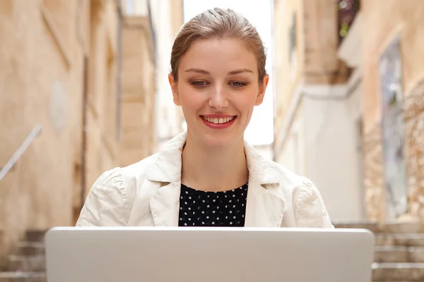 Business woman using a laptop computer outdoors — Zdjęcie stockowe