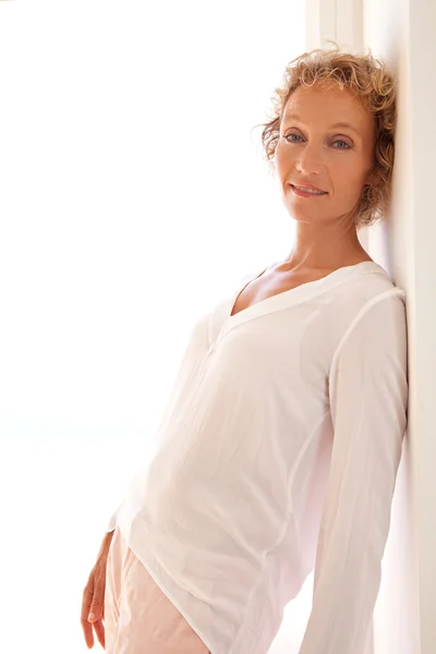 Woman leaning on wall at home — Stock Photo, Image