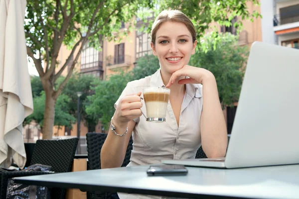 Business woman at a cafe using a laptop computer — Φωτογραφία Αρχείου