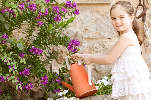 Mädchen gießt die Pflanzen in ihrem Garten — Stockfoto