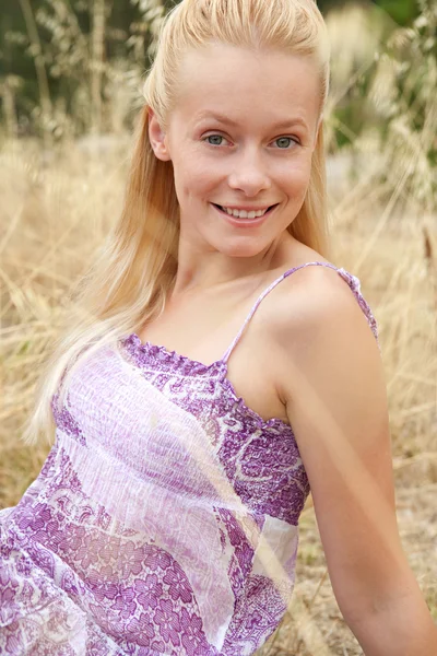 Blond woman relaxing in a field — Stock Fotó