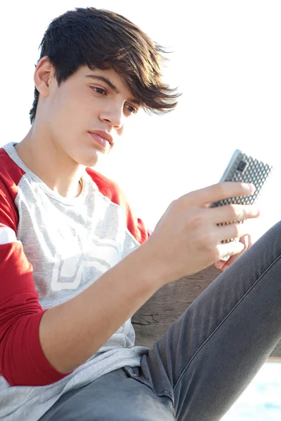 Мальчик, использующий смартфон для работы в сети — стоковое фото
