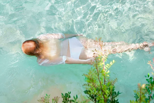 Mujer joven nadando en una piscina — Foto de Stock