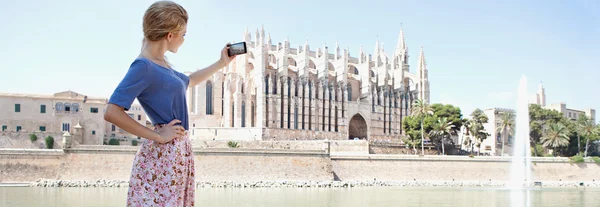 Girl using a smartphone to take photos of a cathedral — Stok fotoğraf