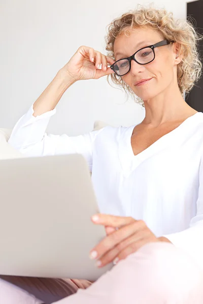 Mujer usando una computadora portátil y trabajando — Foto de Stock