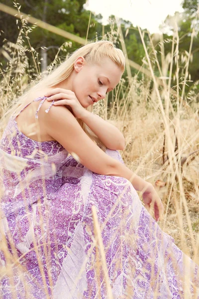 Blond woman relaxing in a field — Stock Photo, Image