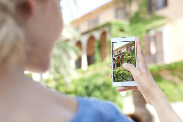 Girl take pictures of a monument on a smartphone — 图库照片