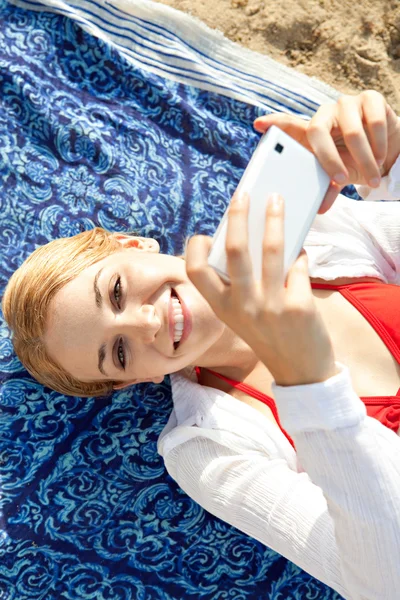 Frau benutzt Smartphone am Strand — Stockfoto