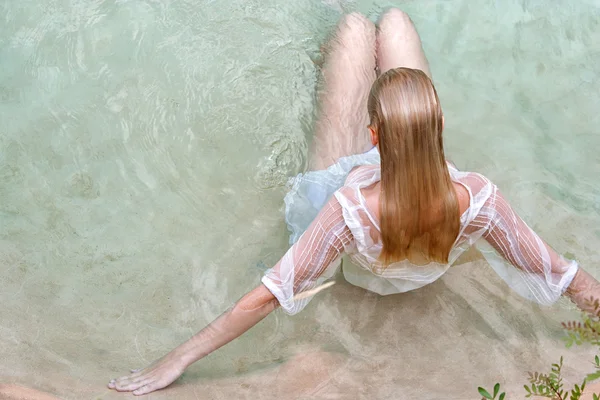 Woman lying and relaxing in a swimming pool — Stok fotoğraf