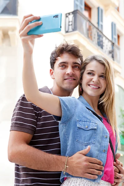 Pareja tomando fotos y selfies usando un smartphone — Foto de Stock