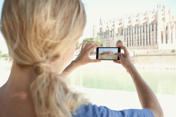 Woman taking photos of a monument cathedral — Stock Fotó