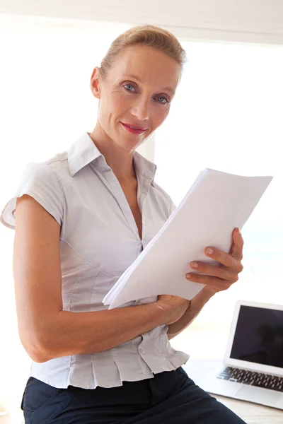 Business woman holding and reading paperwork — ストック写真