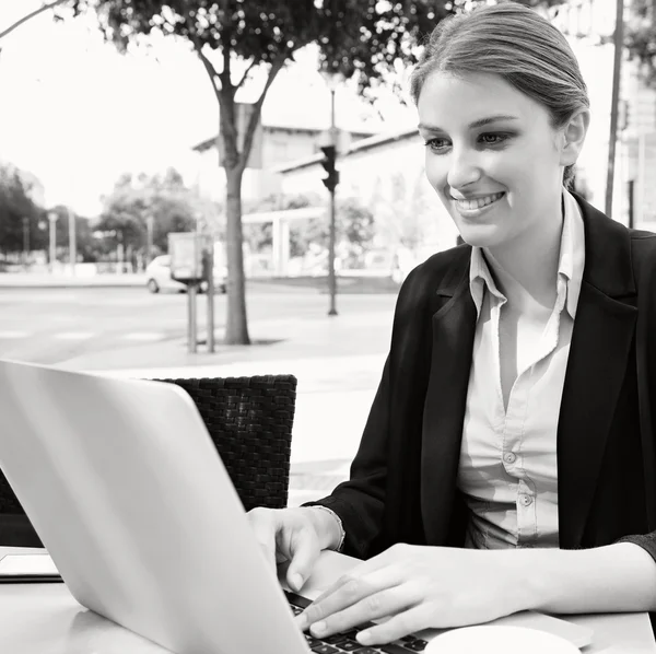 Business woman at a cafe using a laptop computer — Φωτογραφία Αρχείου