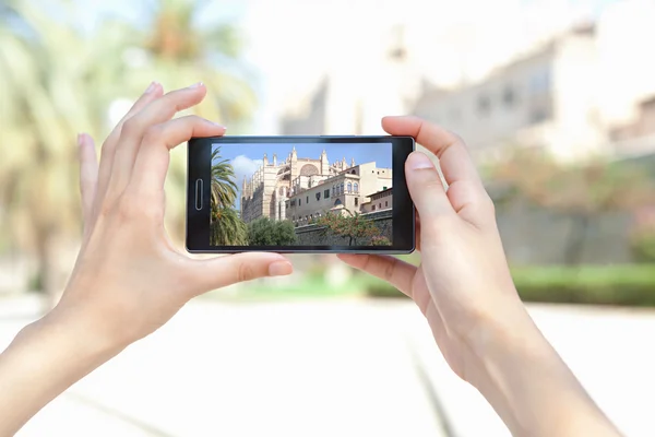 Woman taking pictures of a characterful architecture cathedral — Stockfoto