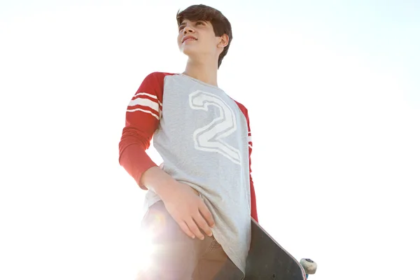 Teenager boy carrying a skateboard — Stock Photo, Image