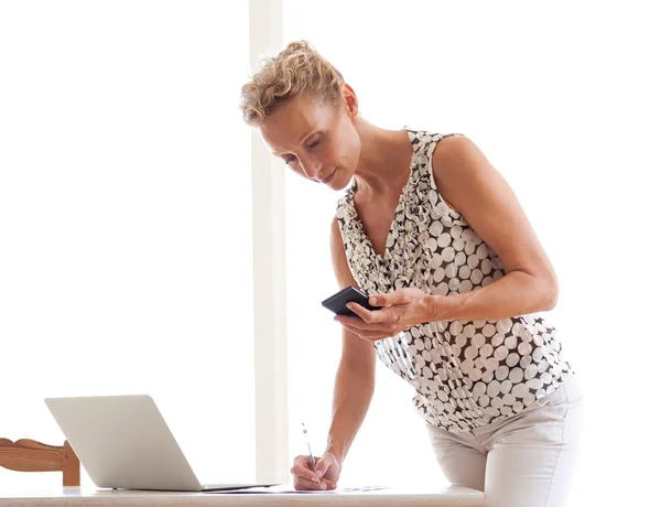 Mulher usando um dispositivo de smartphone em seu escritório — Fotografia de Stock