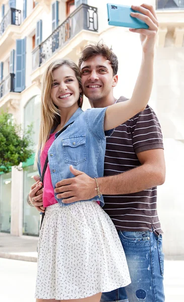 Couple taking pictures and selfies using a smartphone — Stock fotografie