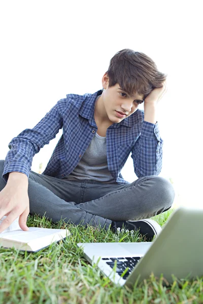 Boy using a laptop and doing his homework — Stok fotoğraf
