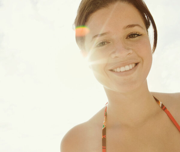 girl smiling and looking at the camera with the sun rays