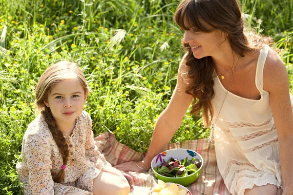 Mother and daughter having a picnic in a garden — Stockfoto