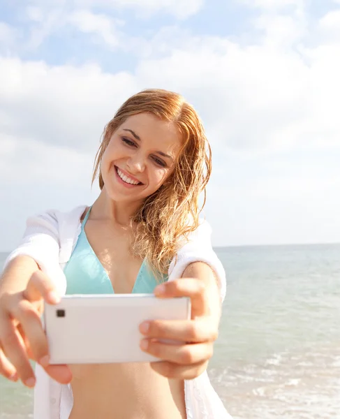 Woman taking selfies pictures on the beach — Zdjęcie stockowe