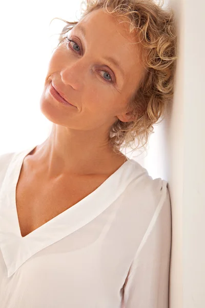 Woman leaning on wall at home — Stock Photo, Image