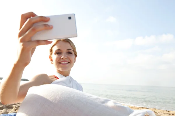 Vrouw met smartphone op het strand — Stockfoto