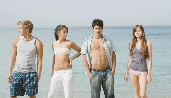 Amis debout ensemble sur une plage — Photo