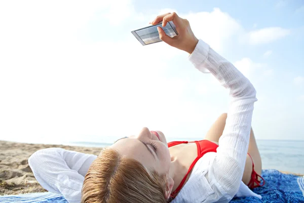 Vrouw met smartphone op het strand — Stockfoto