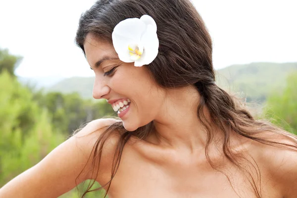 Donna che elassa in natura con un fiore tra i capelli — Foto Stock