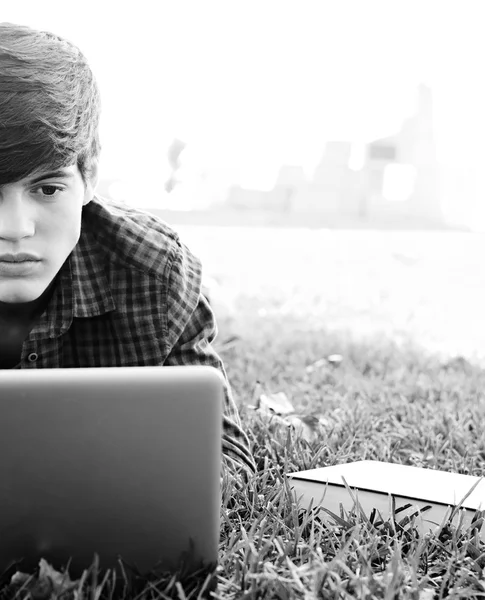 Boy using a laptop computer on a grass — Stock Photo, Image