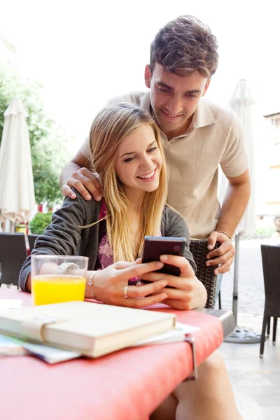 Casal usando um smartphone no café — Fotografia de Stock