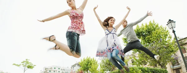 Friends jumping up in the air together Stock Photo