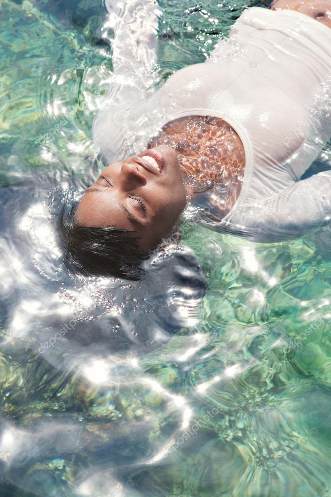 black woman swimming and floating in a sea