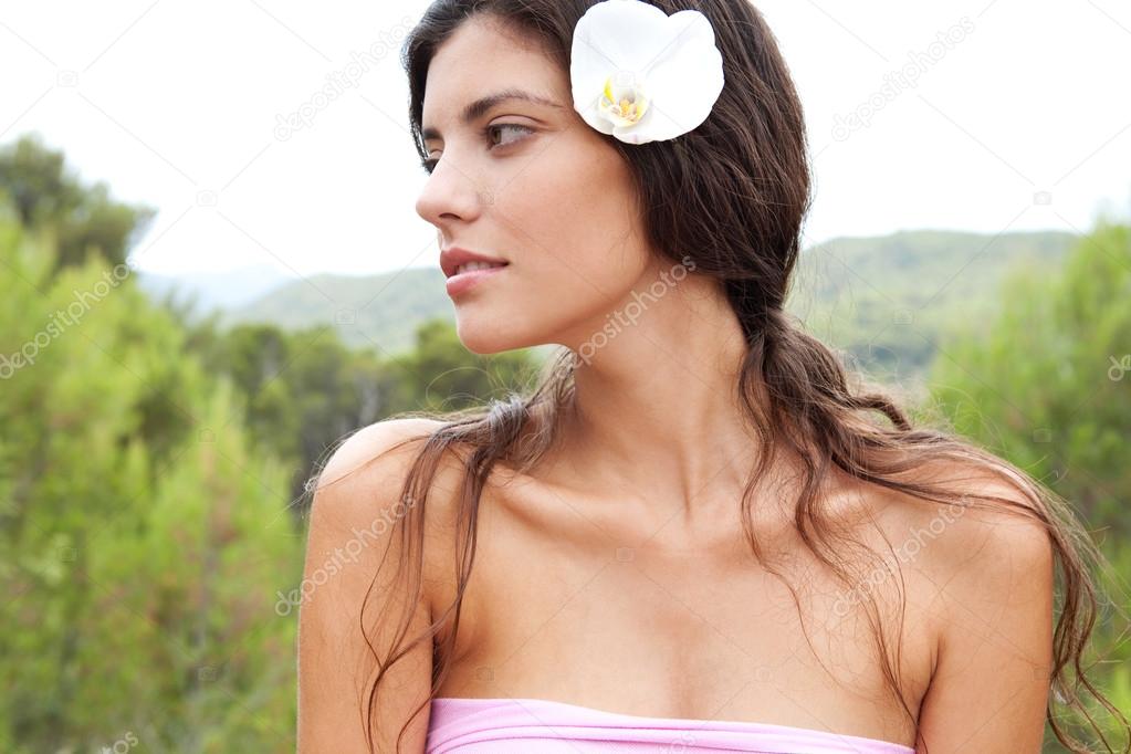 woman elaxing in nature with flower in her hair