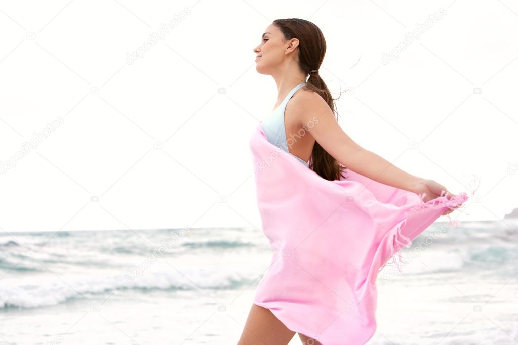 woman on a beach with a pink fabric sarong