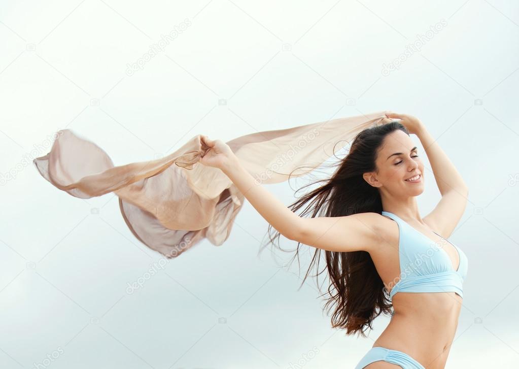 woman on a beach with a silk fabric sarong