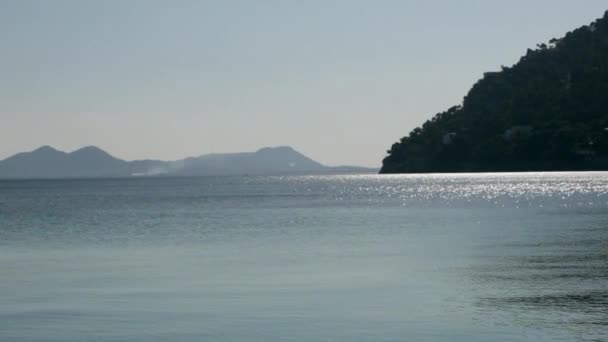 Vue de la mer scintillante avec montagnes vallonnées 