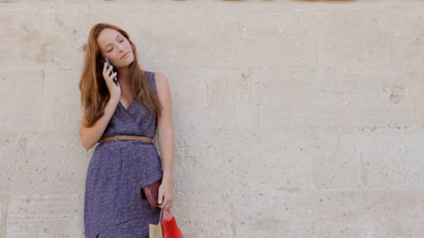 Женщина с сумками звонит на смартфон — стоковое видео
