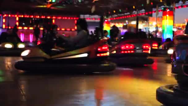 Les voitures de pare-chocs roulent à une foire amusante la nuit — Video