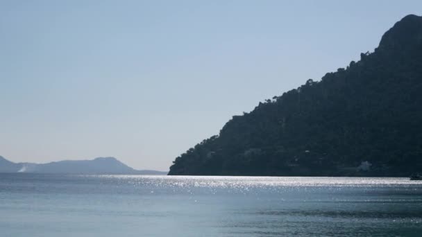 바다에 의해 아래로 굴러 silhouetted 산 — 비디오