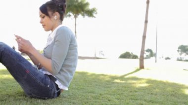 parkta bir mp3 çalar kullanan kadın