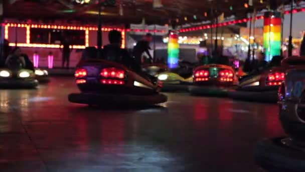 Les voitures de pare-chocs roulent à une foire amusante la nuit — Video