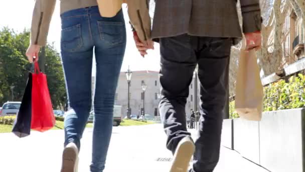 Pareja caminando lejos con bolsas de compras — Vídeos de Stock